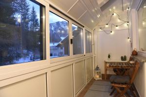 eine abgeschirmte Veranda mit Fenstern und einem Tisch in der Unterkunft Apartma Marni in Kranjska Gora