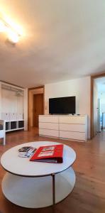 a living room with a table and a tv at Ferienwohnung in Nesselwang, Allgäu Bergfreunde in Nesselwang