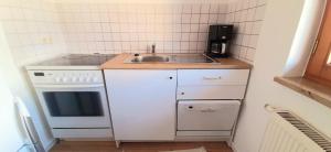 a small kitchen with a sink and a stove at Ferienwohnung in Nesselwang, Allgäu Bergfreunde in Nesselwang