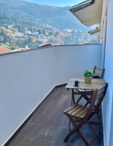 a table and chair on a balcony with a view at StarMountainApartment in Seia
