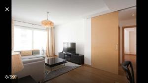 a living room with a couch and a tv at Modern Apartment for Family and Group of Friends in Sacavém
