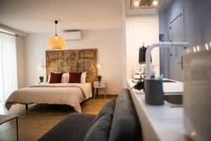 1 dormitorio con 1 cama y 1 sofá en Apartamentos Nueva Ribera, en El Puerto de Santa María