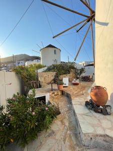 a patio with potted plants and a windmill at The Windmill Serifos in Serifos Chora +42 photos