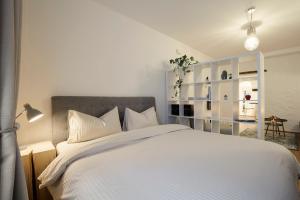 Un dormitorio con una cama grande con sábanas blancas. en KARINA Lauben Lodge, en Egna