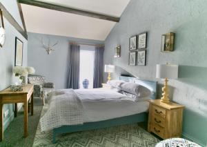 1 dormitorio con 1 cama con pared azul en The Brown Horse Inn en Winster