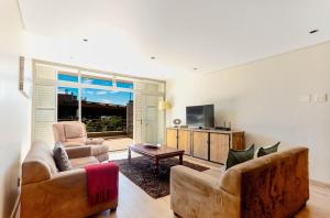 a living room with two chairs and a television at Harbouredge Suites in Cape Town +25 photos