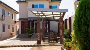 a patio with a table and chairs under a pergola at LaV ROYAL HOTEL in Kumasi