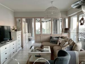 salon z kanapą i telewizorem w obiekcie Biały Apartament Hampton w Playa Baltis w mieście Międzyzdroje
