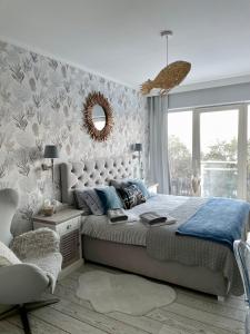 1 dormitorio con 1 cama grande y espejo en Biały Apartament Hampton w Playa Baltis, en Międzyzdroje