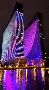 a large building with purple lights on it at night at Black Sea Twin tower in Batumi