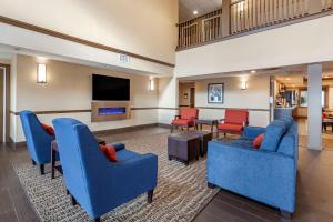 a lobby with blue chairs and a living room at Comfort Inn & Suites Geneva- West Chicago in Geneva