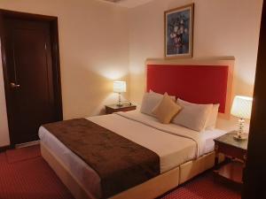 Habitación de hotel con cama grande y cabecero rojo en Genius Service Suites at Times Square Kuala Lumpur en Kuala Lumpur