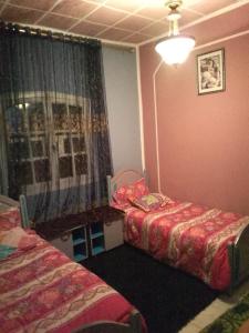 a bedroom with two twin beds and a window at Maison de rêve in Tabarka