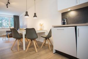 eine Küche mit einem Tisch und Stühlen sowie einem weißen Kühlschrank in der Unterkunft Weltringpark 2-T, Winterberg in Winterberg