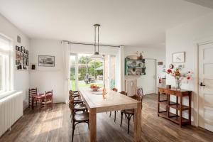 cocina y comedor con mesa y sillas en Vakantiehuis Zeevonk en Bergen aan Zee
