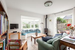 una sala de estar con 2 sofás y una ventana en Vakantiehuis Zeevonk, en Bergen aan Zee