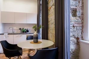 einen kleinen Tisch und Stühle in einer Küche in der Unterkunft Romantic studio in the heart of Trieste in Triest
