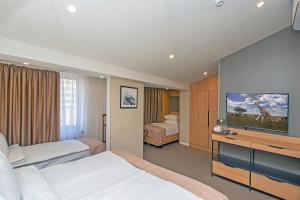 ein Hotelzimmer mit 2 Betten und einem Flachbild-TV in der Unterkunft Cartez Hotel in Yerevan