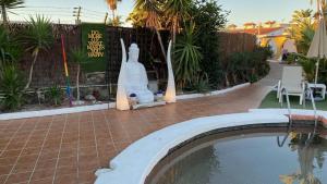a statue of a rabbit next to a swimming pool at Rainbow Golf Bungalows, Gay Men-only Resort in Maspalomas