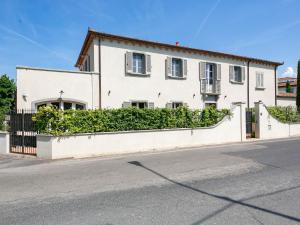 a white house with a hedge in front of a street at Belvilla by OYO Villa Severina in Cortona