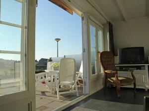een veranda met stoelen, een tafel en een televisie bij Cosy vacation home near the beach in Egmond aan Zee