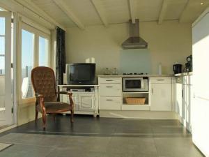 cocina con silla y microondas en Cosy vacation home near the beach, en Egmond aan Zee