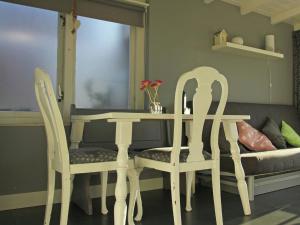 mesa y 2 sillas con mesa y sofá en Cosy vacation home near the beach, en Egmond aan Zee