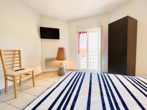 a bedroom with a bed and a chair and a window at Residence Louis Le Lavoir in Bains-les-Bains