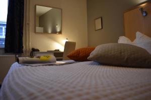 a bedroom with a white bed with a mirror at Hotel Atlanta in Valkenburg