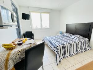 1 dormitorio con 1 cama y 1 mesa con comedor en Residence Louis Place du Marche en Bains-les-Bains