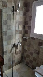 a shower with a glass door in a bathroom at Sarakiniko Rooms in Adamantas