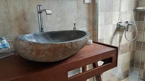 a bathroom with a large stone tub on a wooden counter at Sarakiniko Rooms in Adamantas