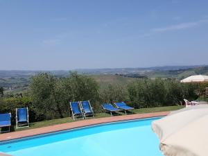 einen Pool mit blauen Stühlen und Aussicht in der Unterkunft Belvilla by OYO Prato in Bagnolo