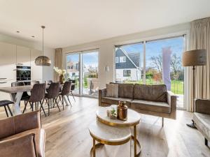 een woonkamer met een bank en een tafel bij Serene Holiday Home in De Koog Texel with Sauna in Westermient