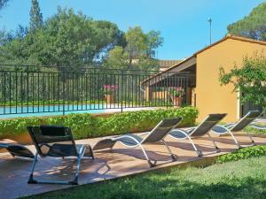 una fila de sillas sentadas en una terraza de madera en Magnificent holiday home with private pool, en Fréjus