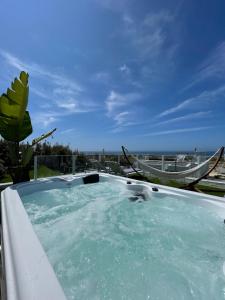 a hot tub with a view of the ocean at We Surf House in Figueira da Foz