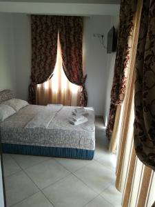 Schlafzimmer mit einem Bett und einem Fenster mit Vorhängen in der Unterkunft Art B in Ohrid