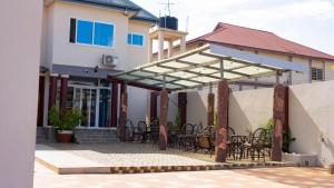 a patio with chairs and tables in a house at LaV ROYAL HOTEL in Kumasi +7 photos