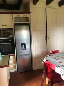 una cucina con frigorifero in acciaio inossidabile e tavolo di Quinta a Argy