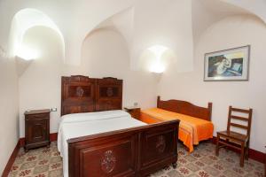 a bedroom with two beds and a chair at Hora Vona in Orosei