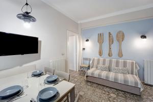 un soggiorno con divano e tavolo di Victoria Apartments Maiolica a Diano Marina