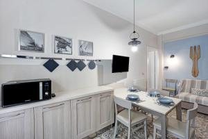 een woonkamer met een kleine tafel en een televisie bij Victoria Apartments Maiolica in Diano Marina