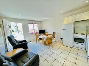 a kitchen and living room with a couch and a table at Residence Louis Le Lavoir in Bains-les-Bains