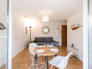 uma sala de jantar e sala de estar com mesa e cadeiras em Apartment in a residence by the sea em Port-en-Bessin-Huppain