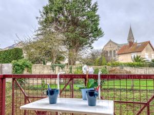 uma mesa com dois copos em cima de uma cerca em Apartment in a residence by the sea em Port-en-Bessin-Huppain