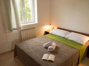 un letto con due asciugamani e due libri sopra di Captivating Holiday Home in Pako tane with Swimming Pool a Pakoštane