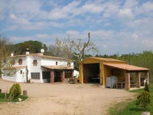 ein Haus auf einem Feld mit einem Feldweg in der Unterkunft Belvilla by OYO Can Rajoler in Riudarenes