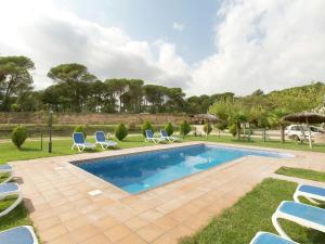 una piscina con tumbonas y un patio en Belvilla by OYO Can Rajoler, en Riudarenes