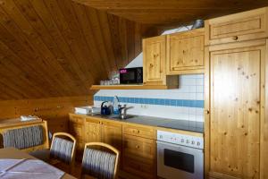 kuchnia z drewnianymi szafkami i kuchenką z piekarnikiem w obiekcie Wallackhaus hütte w mieście Untertauern