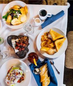 a white table with plates of food on it at Visitor's Inn in Jambiani